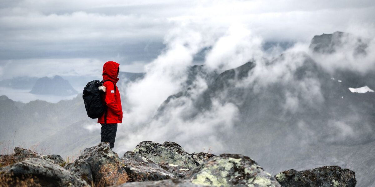 Préparer sa valise pour la Norvège : randonneuse face aux montagnes norvégiennes